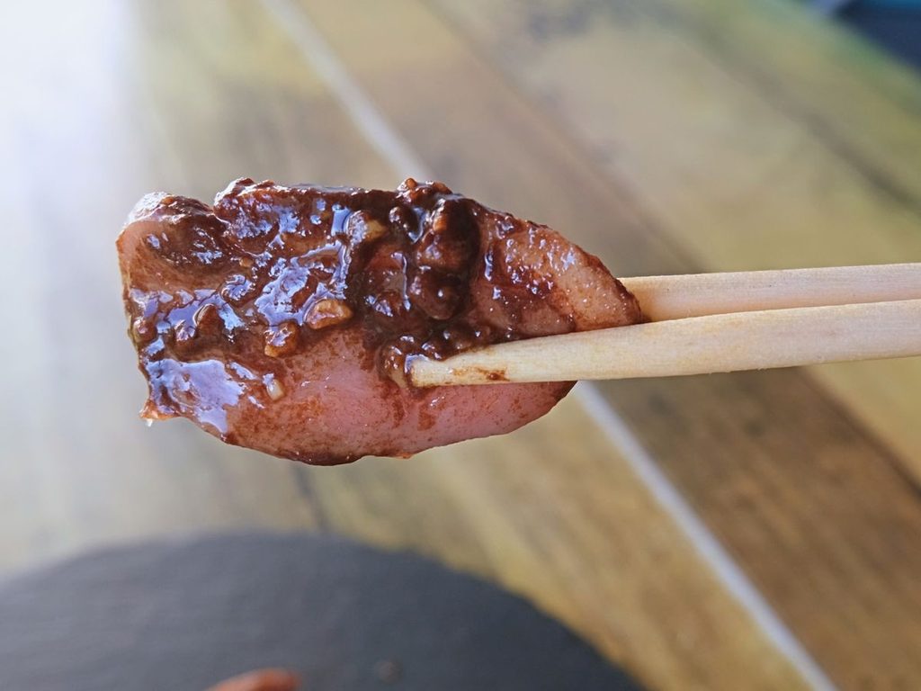 合鴨ロースト 甜麺醤のソースを箸で持ち上げた様子