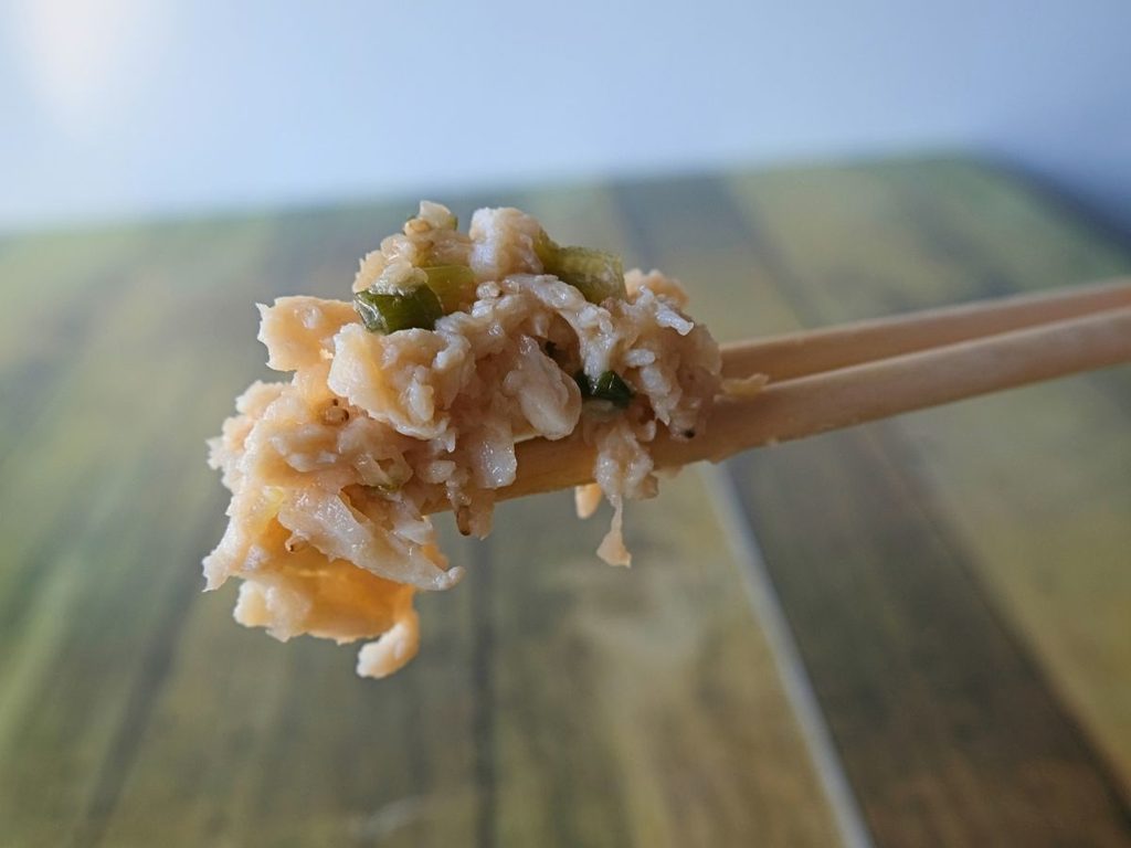 蒸し鶏と香味野菜のソースを箸で持ち上げた様子