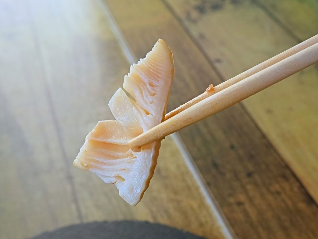 牡蠣の豆豉炒めに入っていたたけのこを箸で持ち上げた様子