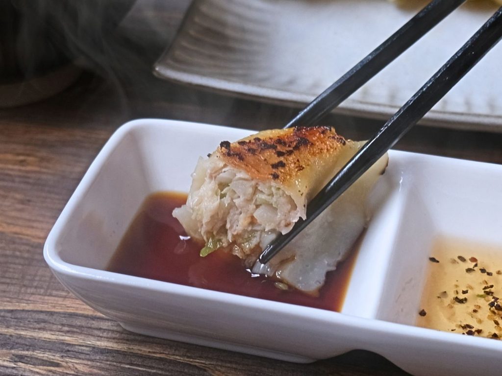 魔法の焼き餃子を醤油につけて食べる様子