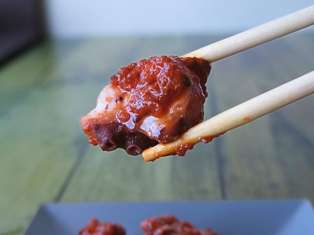 真ダコのトマト煮を箸で持ち上げた様子